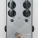 Stříbrný efekt pedál s čtyřmi černými oválnými ovladači. Na pedálu jsou nápisy LEVEL, DRIVE, MIX a MIDS, dále značení 50 Hz, 500 Hz, 100 Hz, 1 kHz, L…