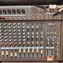 Šedý mixážní pult značky YAMAHA, model MXDR MM1402. Zařízení je osazeno řadou knoflíků, posuvníků a vstupních konektorů typu XLR a jack. Na povrchu j…