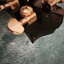 Detail hlavy černého strunového nástroje se zlatými ladicími mechanismy. Na mechanismu je viditelný nápis GROVER. Na povrchu hlavy je vyražené sériov…