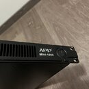 Černý elektronický přístroj s kovovým šasi a ventilačními otvory v horní části. Na předním panelu je bílý nápis App® a modelové označení MA4-1000. Ve…