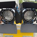 Dvě černé reflektory s kovovými clony umístěné na žlutém transportním kufru. Světla mají kulaté skleněné čočky s výrazným žebrováním. Na přístrojích…
