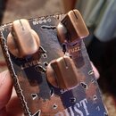 Efektový pedál s kovovým šasi v rezavém, hnědo-modrém provedení. Na horní straně jsou tři bronzové otočné knoflíky s popisky LEVEL, FUZZ a SATURATION…