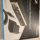 Fotografie znázorňuje krabici s produktem. Na černé povrchové části je bílý nápis Evolution Wireless Digital Instrument Set a logo SENNHEISER. Na obr…