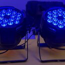 Dvě černé LED par světla s kulatým hlavovým částem, v němž jsou rozmístěny modře svítící diody. Každý reflektor je umístěn na černém kovovém stojanu…