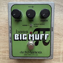 Zelený efekt pedál v kovovém šasi s nápisy bass BIG MUFF a electro-harmonix NEW YORK CITY, USA. Na horní straně jsou tři černé ovládací knoflíky s po…