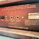 Fotografie zachycuje zadní panel kytarového komba s červeným povrchem. Jsou zde vidět čtyři konektory s popisky SPEAKER 8 OHMS, FOOT SWITCH, POWER AM…