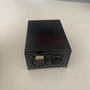 Černý obdélníkový box z kovového materiálu. Na jedné straně jsou umístěny dva konektory, jeden s pěti piny a druhý s pěti piny v jiném rozestupu. Nad…