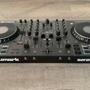 Černý DJ kontrolér s dvěma jog-koly a centrálním mixážním sekcí. Na přístroji jsou viditelné nápisy Numark, serato a modelové označení NS4 FX. V horn…