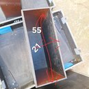 Fotografie zachycuje vnitřek transportního kufru z tmavého materiálu s červeným vnitřním povrchem. Na stěně kufru jsou červeně nakreslené šipky a bíl…