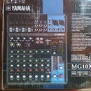 Fotografie zobrazuje míchací pult Yamaha MG10XU v původním kartónovém obalu. Na přístroji je viditelné logo YAMAHA a označení modelu MIXING CONSOLE M…