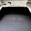 Detailní pohled do vnitřku světle hnědého nástroje. Na tmavém, texturovaném povrchu je bílým nápisem uvedeno K 38 246. V horní části je vidět kousek…