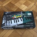 Fotografie znázorňuje kartonovou krabici s produktem Novation Launchkey Mini. Na povrchu je zobrazen obrázek černého kompaktního klávesového kontrolé…