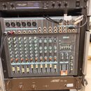 Hliníkový rack s několika zařízeními. V horní části je procesor s nápisem REV100 DIGITAL REVERBERATOR, uprostřed mixážní pult YAMAHA MODEL MM1402 s ř…