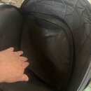 Fotografie zachycuje vnitřek černého polstrovaného obalu z textilního materiálu. Uvnitř je vidět všívaná kapsa a vyšívané prošívání stěn. Na povrchu…