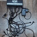 Černý napájecí adaptér pro pedály s nápisy ENGL a Power Tap. Zařízení obsahuje deset výstupů označených jako 9V DC Outputs, z nichž osm má nad sebou…