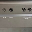 Detail zadní strany elektronického nástroje s řadou připojovacích portů. Jsou zde viditelné nápisy TO DEVICE, USB, TO HOST, MIC INPUT, AUX IN, PHONES…