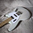 Světle šedá elektrická kytara s bílým pickguardem a hnedým javorovým hmatníkem. Nástroj má dva humbuckery, tři černé ovládací knoflíky a chromovaný m…