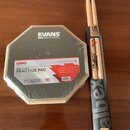 Na fotografii je v originálním balení cvičný pad značky EVANS s nápisem REALFEEL a MOUNTABLE PRACTICE PAD. Pad má šestiúhelníkový tvar, šedý povrch a…