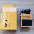 Žlutý efekt pedál Boss Acoustic Simulator AC-3 v originální žluté krabici. Na pedálu jsou tři ovládací knoflíky, červená kontrolka s nápisem CHECK a…