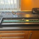 Černý syntetizátor Roland JUNO-1 bez spodního krytu, v němž jsou viditelné vnitřní elektronické платы a zapojení. Na horním panelu je logo Roland a n…