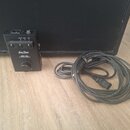 Černý kompaktní zesilovač s nápisy Harley Benton, GPA-100 a Guitar Power Amplifier. Zařízení má tři přepínače, jeden otočný knoflík a kontrolky s pop…