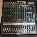 Černý mixovací pult s nápisem MIXING CONSOLE MGP16X. Zařízení obsahuje více vstupních kanálů s řadou potenciometrů, přepínačů a červenými kontrolkami…
