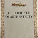 Fotografie zobrazuje papírový certifikát s ozdobným hnědým rámem. V horní části je logo Boutique a pod ním nápis VINTAGE & FINE. Uprostřed je uveden…