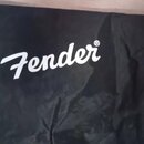 Černý textilní obal na hudební nástroj. Uprostřed je bílý nápis Fender s registrace značky (®). Povrch materiálu vykazuje vrásky.