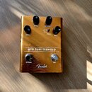 Zlatý kytarový efekt s nápisem MTG TUBE TREMOLO a logem Fender. Na horní straně jsou čtyři černé otočné ovnovátka s popisky LEVEL, SPEED, INTENSITY a…
