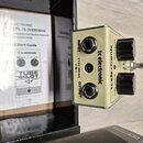 Kremově bílý kytarový efekt s nápisy tc electronic a TUBE PILOT. Na horní straně jsou dva černé ovládací knoflíky s popisky TUBE DRIVE a OUT LEVEL. B…