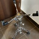 Chromovaný stojan na nástroje s čtyřramennou horní částí a černými gumovými oporami. Na středním sloupku je viditelný nápis "HAMMOND". Stojan stojí n…