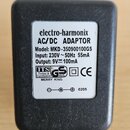 Černý plastový AC/DC adaptér značky electro-harmonix. Na bílém štítku je uveden Model: MKD-350900100GS, Input: 230V~ 50Hz 55mA a Output: 9V⎓100mA. Js…
