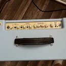 Světle modrý kytarový zesilovač s ovládacím panelem v krémové barvě. Na panelu jsou nápisy INPUT, CLEAN, OVERDRIVE, OD EQUALISATION, REVERB a POWER,…