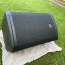 Černý stage monitor s kovovou mřížkou v přední části. Na pravé straně mřížky je umístěn malý stříbrný obdélníkový štítek s logem a nápisem ALTUS. Pov…