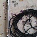 Stříbrný kondenzátorový mikrofon s mřížkou v horní části a připojeným černým kabelem. Na těle mikrofonu je viditelný nápis "MACON". Povrch nástroje v…