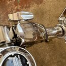 Detail chromovaného bubeníckého kování z kovu. Na povrchu je vyryto logo Pearl a nápisy ADVANCED HARDWARE SYSTEM. Povrch vykazuje drobné škrábance a…