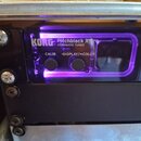 Černý chromatický ladič s fialovým podsvícením, který je osazen do rackového šasi. Na zařízení jsou bílé nápisy KORG, Pitchblack X Pro a CHROMATIC TU…