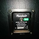 Fotografie zachycuje zadní štítku kytarového reproduktoru značky Randall. Na černém plastovém podkladu je bílý nápis MODEL NO. RX412M, POWER HANDLING…