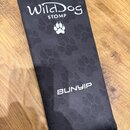 Černý obdélníkový textilní obal s potiskem tlap psů. V horní části je bílý nápis WildDog a pod ním slovo STOMP s ikonou tlapky. Ve spodní části je bí…