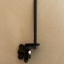 Černý kovový tremolo páka (whammy bar) s dlouhou rukojetí. Na spodní části je vidět kovový kuličkový mechanismus a plastové uthnutí. Nástroj nevykazu…