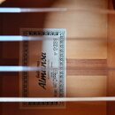 Fotografie zachycuje vnitřek akustické kytary s viditelnou štítkovou nálepkou. Na bílém štítku s ozdobným rámem je uveden nápis Guitarras Almansa, AL…