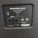 Fotografie zachycuje zadní panel reproduktoru značky Hartke, model HL210 Hytdrive. Panel obsahuje dva vstupní konektory označené jako INPUT (SELECT O…
