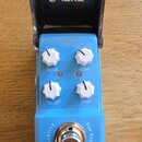 Modrý efekt pedál s nápisy Blue Rain, Overdrive a True Bypass. Na horní straně jsou čtyři bílé oválné knoflíky s popisky VOLUME, DRIVE, HIGH a LOW. P…