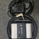 Na fotografii je stříbrný kovový box s nápisem LINE 6 a označením XPS-D1. Zařízení má přepínač mezi režimy MIC LEVEL a LINE LEVEL, vstup POWER a výst…