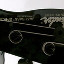 Detail hlavy černé basové kytary se značkou Fender. Na povrchu jsou nápisy JAZZ BASS ® SPECIAL, MADE IN MEXICO a SERIAL NUMBER MX1100200. Jsou vidět…