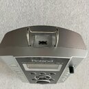 Stříbrošedý elektronický perkusní modul s kovovou rukojetí. Na předním panelu je nápis Roland PERCUSSION SOUND MODULE TD-9 a tlačítka POWER, QUICK RE…