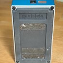 Zadní strana modrého efektového pedálu s šedým plastovým dnem. Na horní části je vstup pro napájení a červený nápis USE BOSS PSA ADAPTOR ONLY (9V DC)…