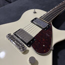 Kytara s krémovým povrchem těla a hnědým plechtrem s mramorovaným vzorem. Nástroj má dva humbuckery s kovovými kryty a chromovaný most. Na těle nejso…