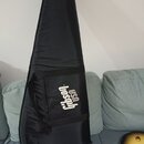 Černý polstrovatý pouzdro na kytaru z textilního materiálu. Na přední straně je bílý nápis gibson USA. Pouzdro vykazuje mírné pomačkání povrchu.