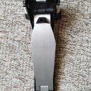 Fotografie znázorňuje pedál k elektronické bicí sadě s kovovou stoupací plochou stříbrné barvy a černým plastovým základním mechanismem. Na spodní čá…